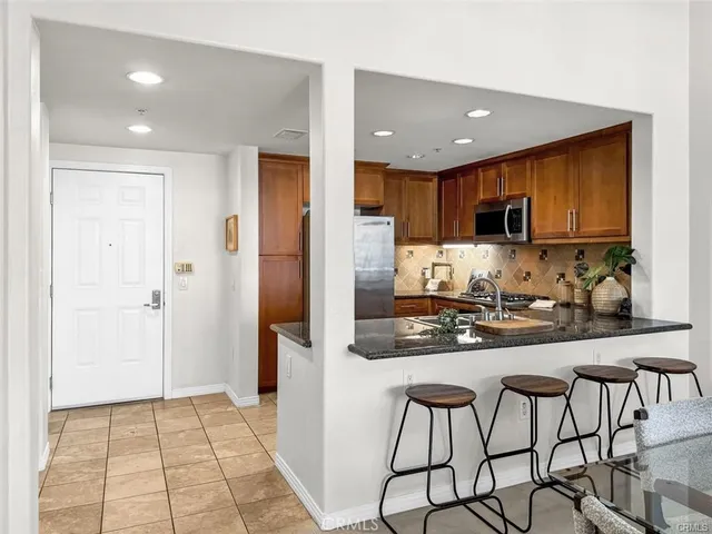 a kitchen with stainless steel appliances granite countertop a refrigerator and a stove top oven