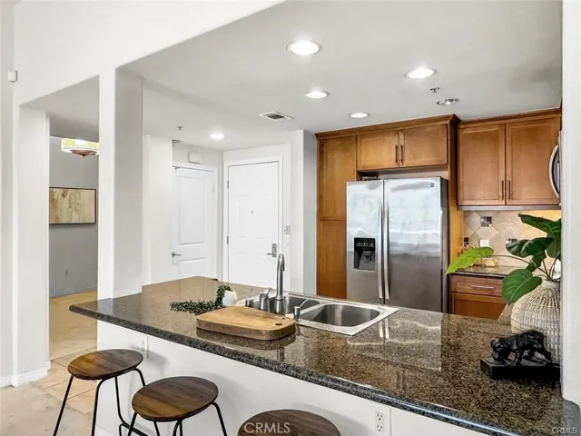 a kitchen with sink refrigerator and dining table