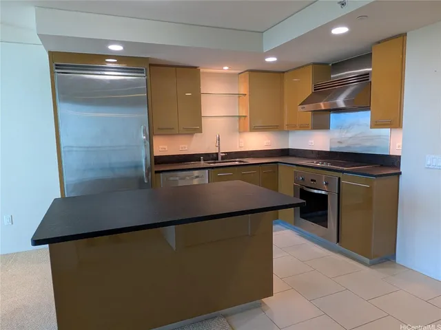 a kitchen with kitchen island stainless steel appliances a sink stove and refrigerator