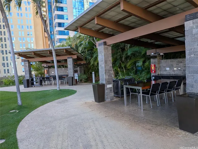 a view of a patio with table and chairs potted plants and floor to ceiling window