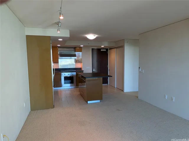 an empty room with kitchen and a fireplace