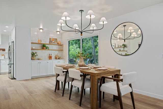 a view of a dining room with furniture a chandelier and wooden floor