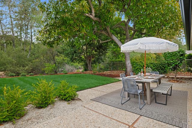 a view of a backyard with furniture and a garden
