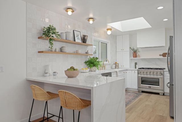 a kitchen with kitchen island a stove a sink and a refrigerator