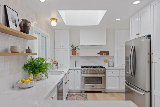 a kitchen with stainless steel appliances a stove a sink and a refrigerator