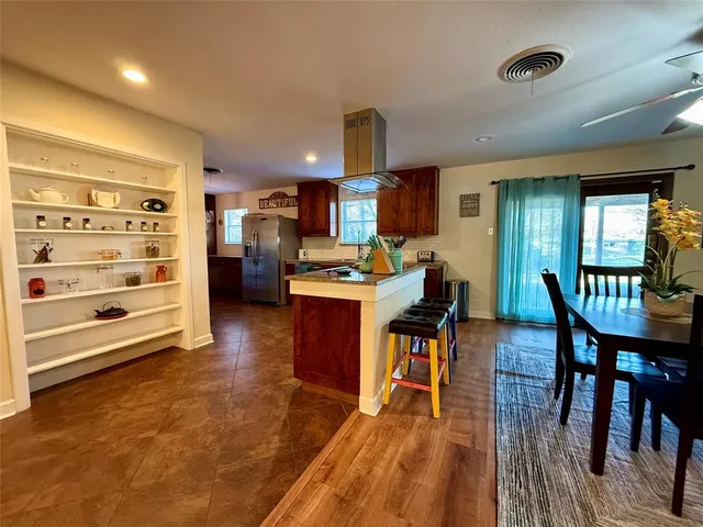 a living room with stainless steel appliances kitchen island granite countertop furniture and a wooden floor
