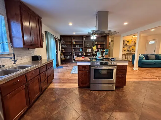 a kitchen with stainless steel appliances granite countertop a stove a sink and a refrigerator