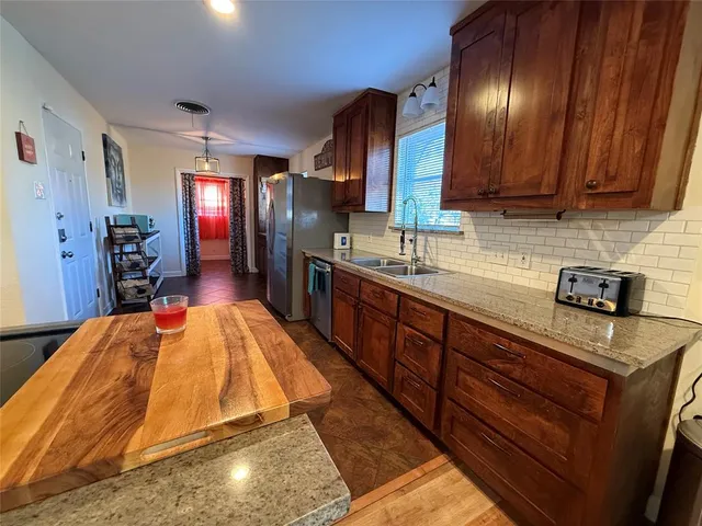 a kitchen with stainless steel appliances granite countertop wooden cabinets a sink and dishwasher
