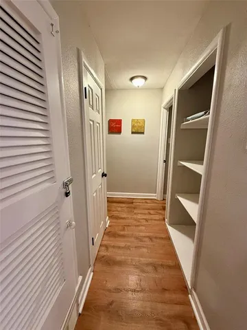 a view of a hallway with wooden floor and staircase