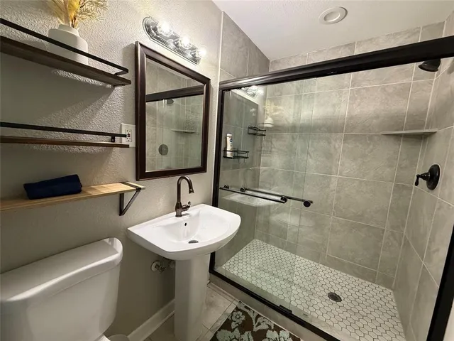 a bathroom with a sink and mirror with toilet