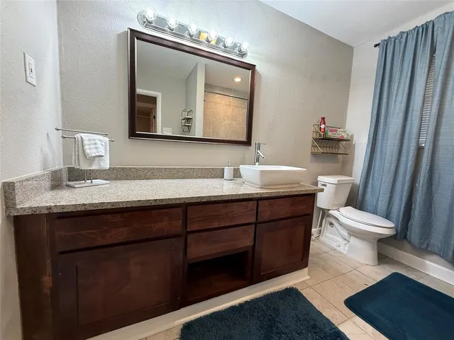 a bathroom with a toilet a sink a vanity and mirror