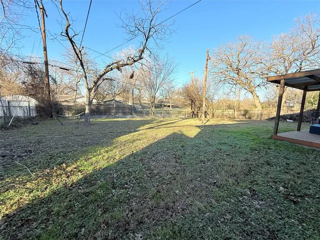 a view of yard with tree and wooden fence