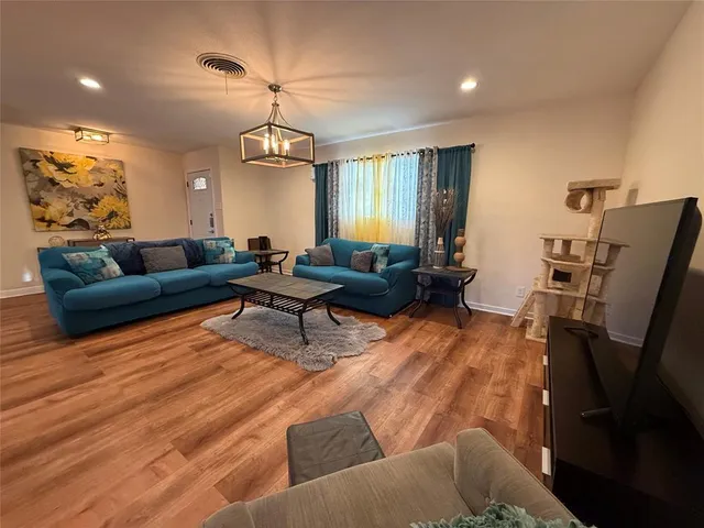 a living room with furniture and a chandelier