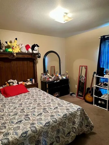 a bedroom with bed and dresser