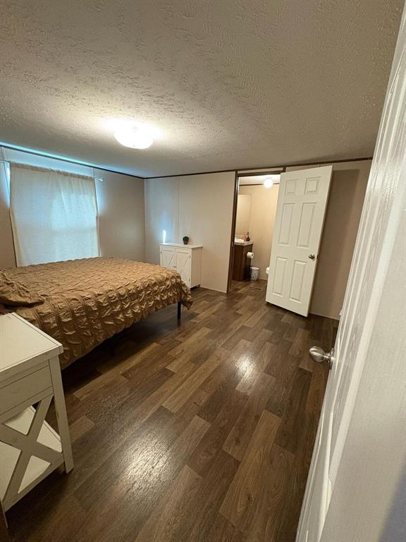 11093 Alta Vista Road Fort Worth, TX 76244 - Photo 4 of 10 a bedroom with a bed and wooden floor