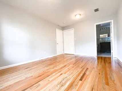 a view of empty room with wooden floor