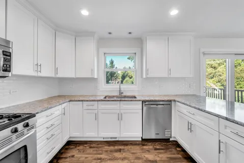 a kitchen with granite countertop white cabinets white stainless steel appliances and sink