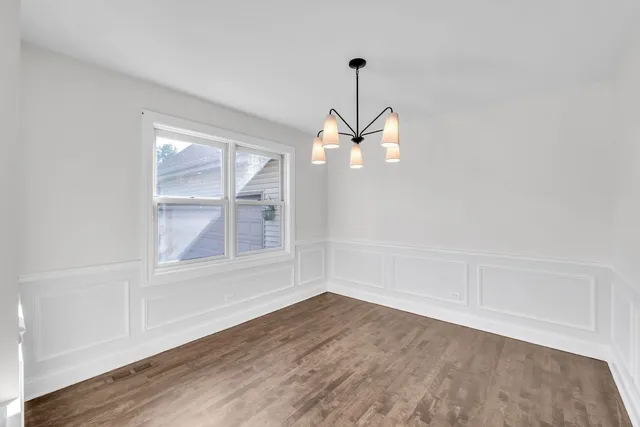 a view of empty room with wooden floor and window