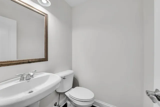 a bathroom with a toilet a sink and mirror