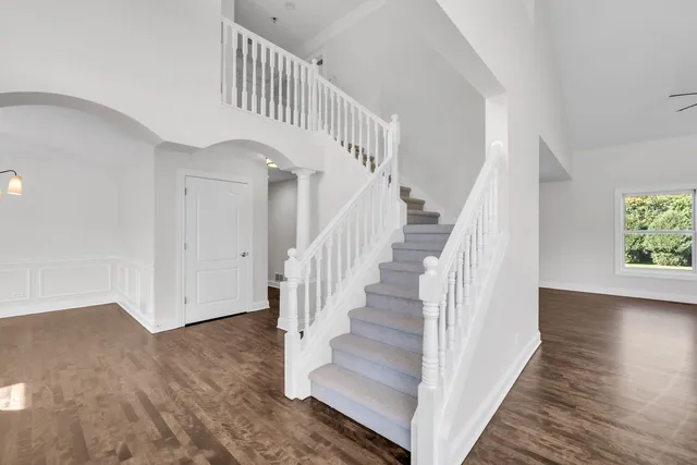 a view of staircase with wooden floor and white walls