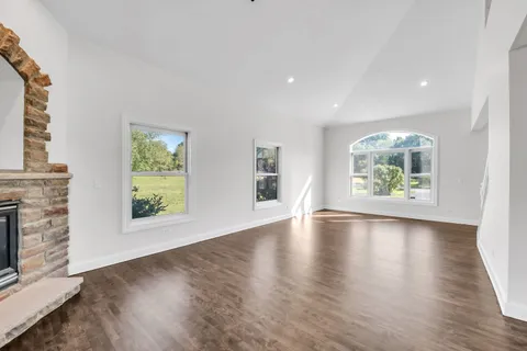 an empty room with window and wooden floor