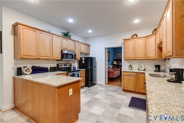a kitchen with stainless steel appliances granite countertop a stove sink microwave and refrigerator