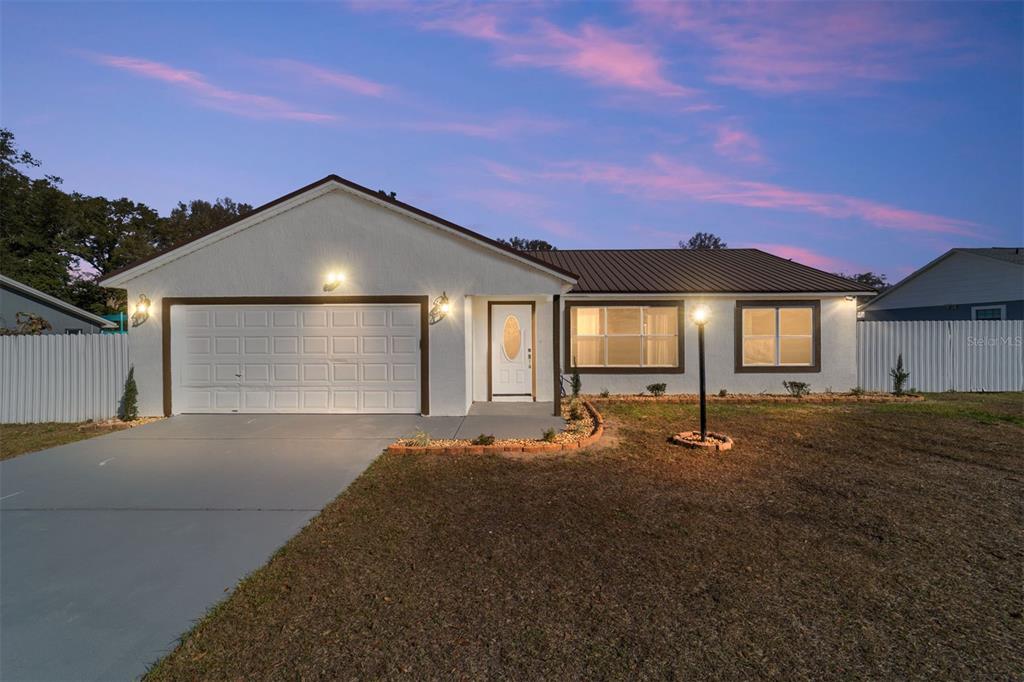 6821 Southwest 108th Street Ocala, FL 34476 - Photo 1 of 1 a front view of a house with a yard and garage