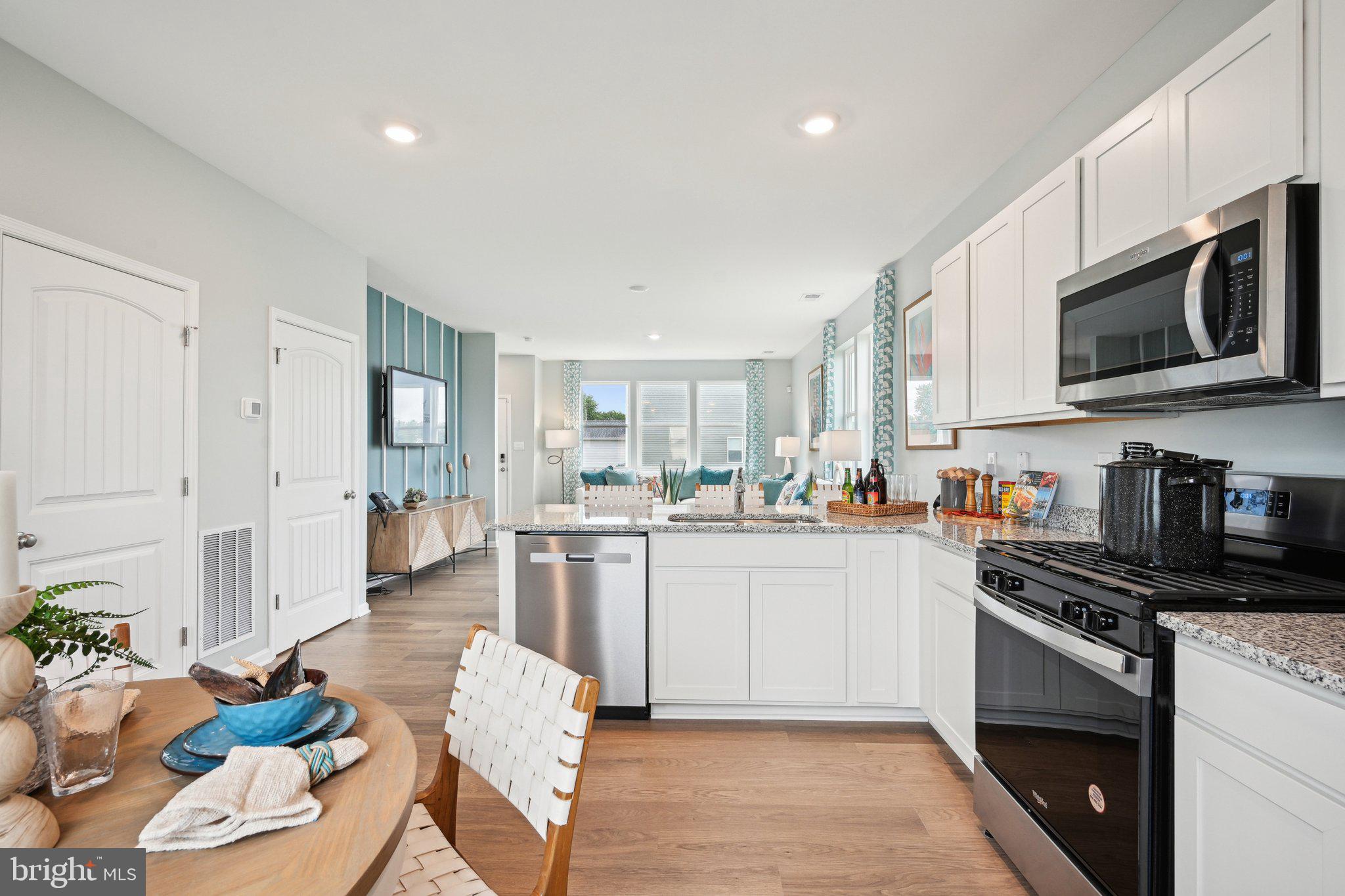 513 Colette Street Ellendale, DE 19941 - Photo 12 of 30 a kitchen with stainless steel appliances kitchen island granite countertop a stove a sink dishwasher and white cabinets with wooden floor