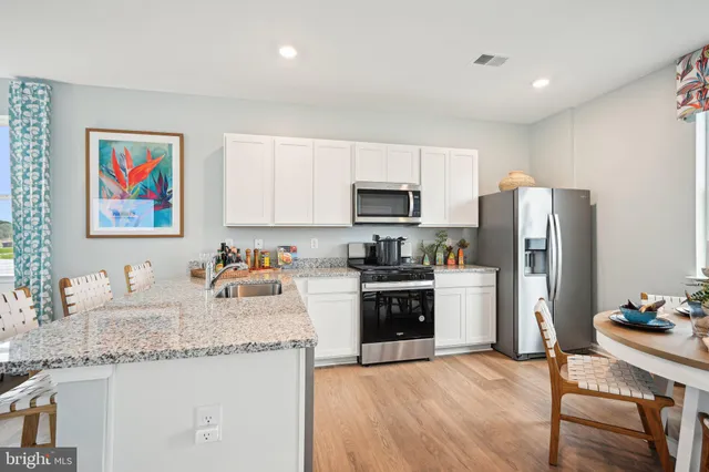 a kitchen with stainless steel appliances granite countertop a refrigerator stove microwave and sink