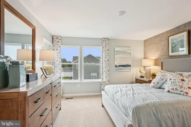 a bedroom with a large bed and a flat tv screen on dresser