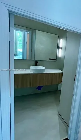 a bathroom with mirror and window
