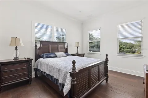 a view of a swimming pool with a lawn chairs under palm trees