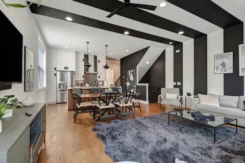 a living room with furniture kitchen view and a flat screen tv