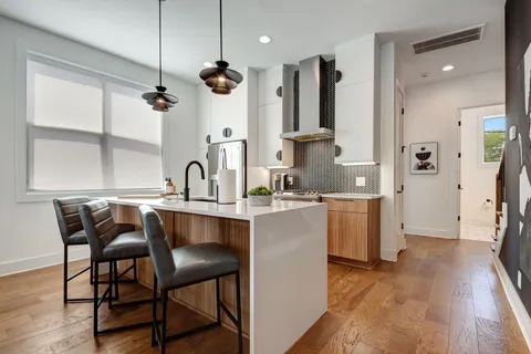 a kitchen with granite countertop white cabinets and stainless steel appliances