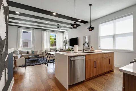 a open kitchen with stainless steel appliances granite countertop a sink dishwasher a stove and a refrigerator with wooden floor