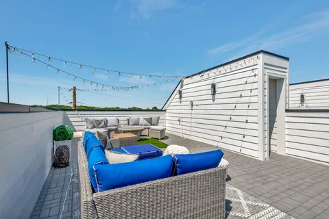 a view of a patio with couches chairs potted plants and water view