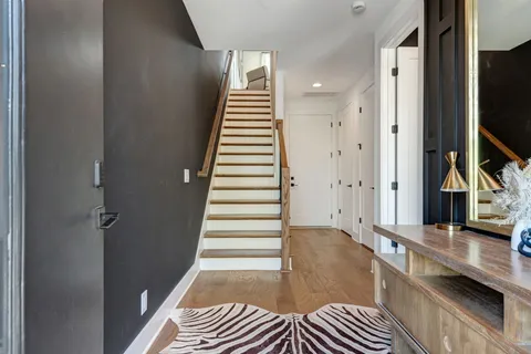 a view of a hallway with entryway and wooden floor
