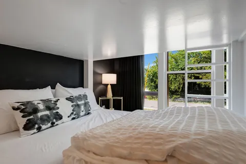 a large bed sitting in a bedroom next to a window
