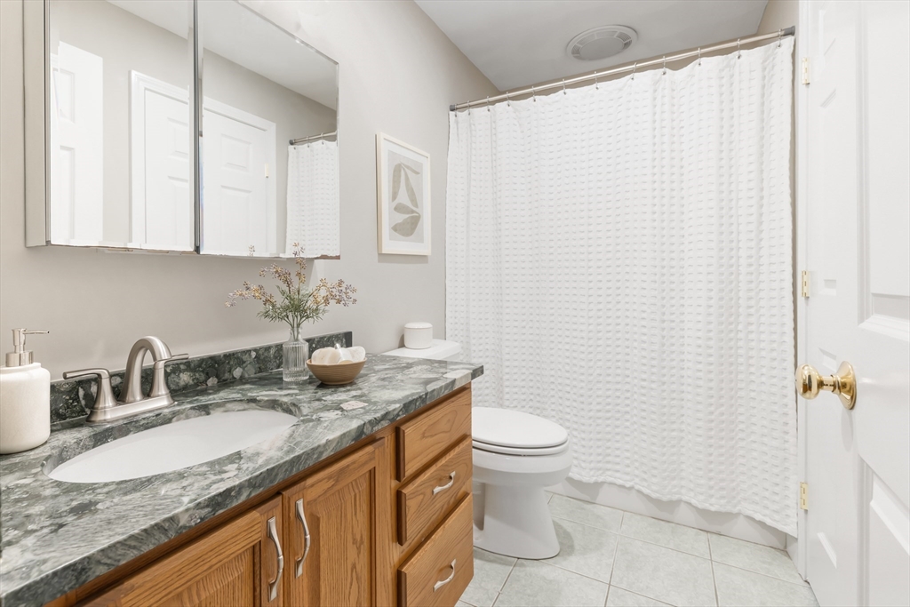 70 Sylvan Street, Unit 70 Melrose, MA 02176 - Photo 11 of 20 a bathroom with a granite countertop sink and a mirror