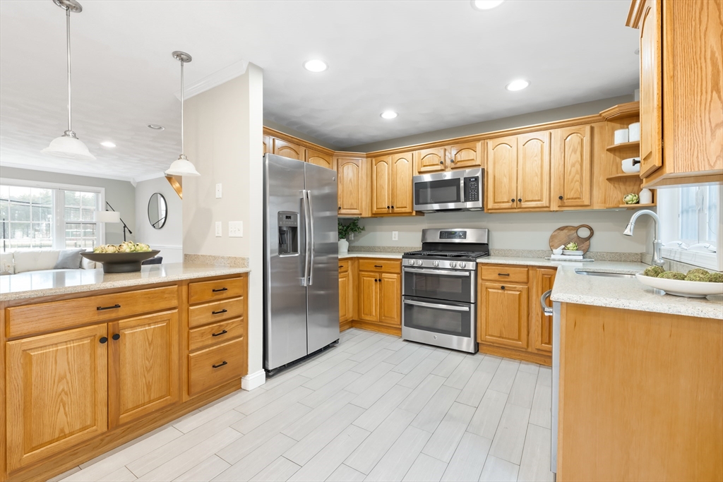 70 Sylvan Street, Unit 70 Melrose, MA 02176 - Photo 5 of 20 a kitchen with granite countertop white cabinets and stainless steel appliances