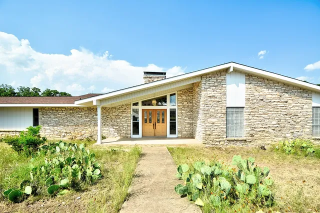 a front view of a house with sign board