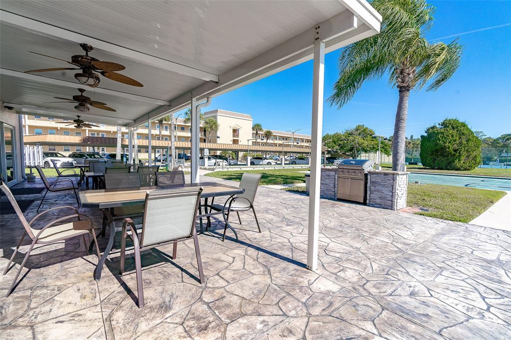 1 Boca Ciega Point Boulevard, Unit 113 St. Petersburg, FL 33708 - Photo 34 of 36 a view of a swimming pool with a table and chairs