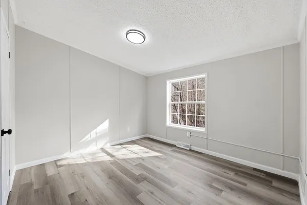 an empty room with a window and a sink