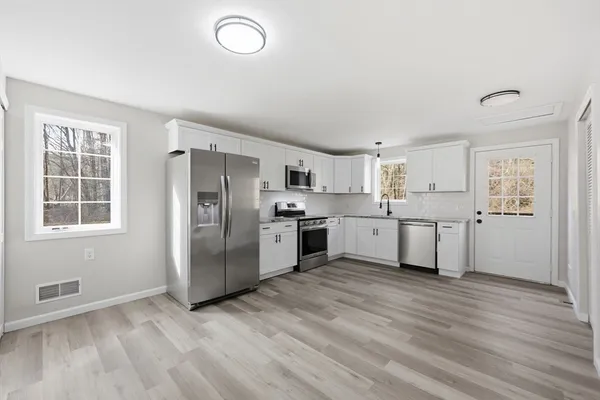 a kitchen with white cabinets stainless steel appliances and sink