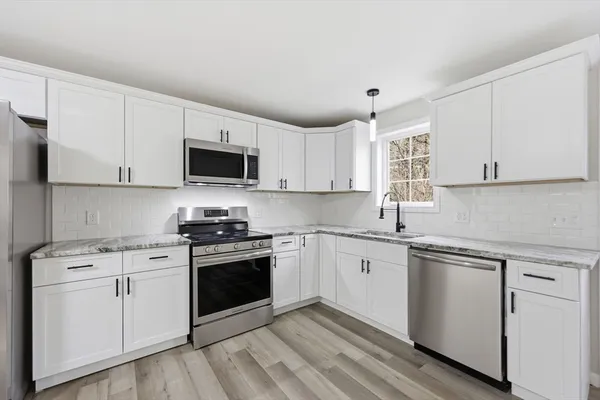 a kitchen with white cabinets and white appliances