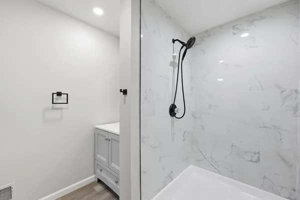 a view of empty room with wooden floor and fan