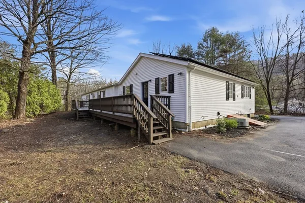 a view of backyard with deck and wooden fence