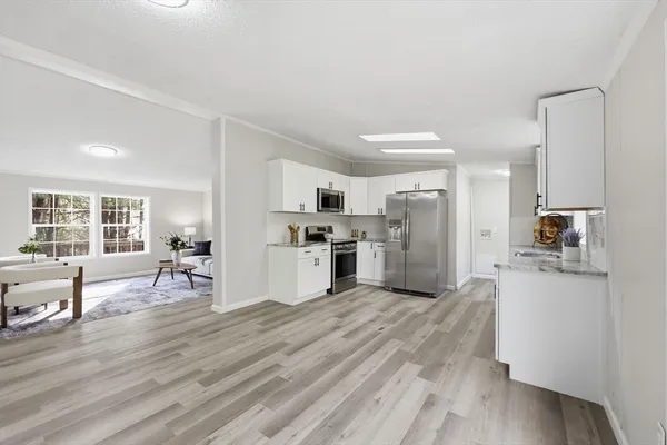 a large kitchen with cabinets wooden floor and stainless steel appliances
