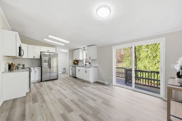 a kitchen with white cabinets and stainless steel appliances