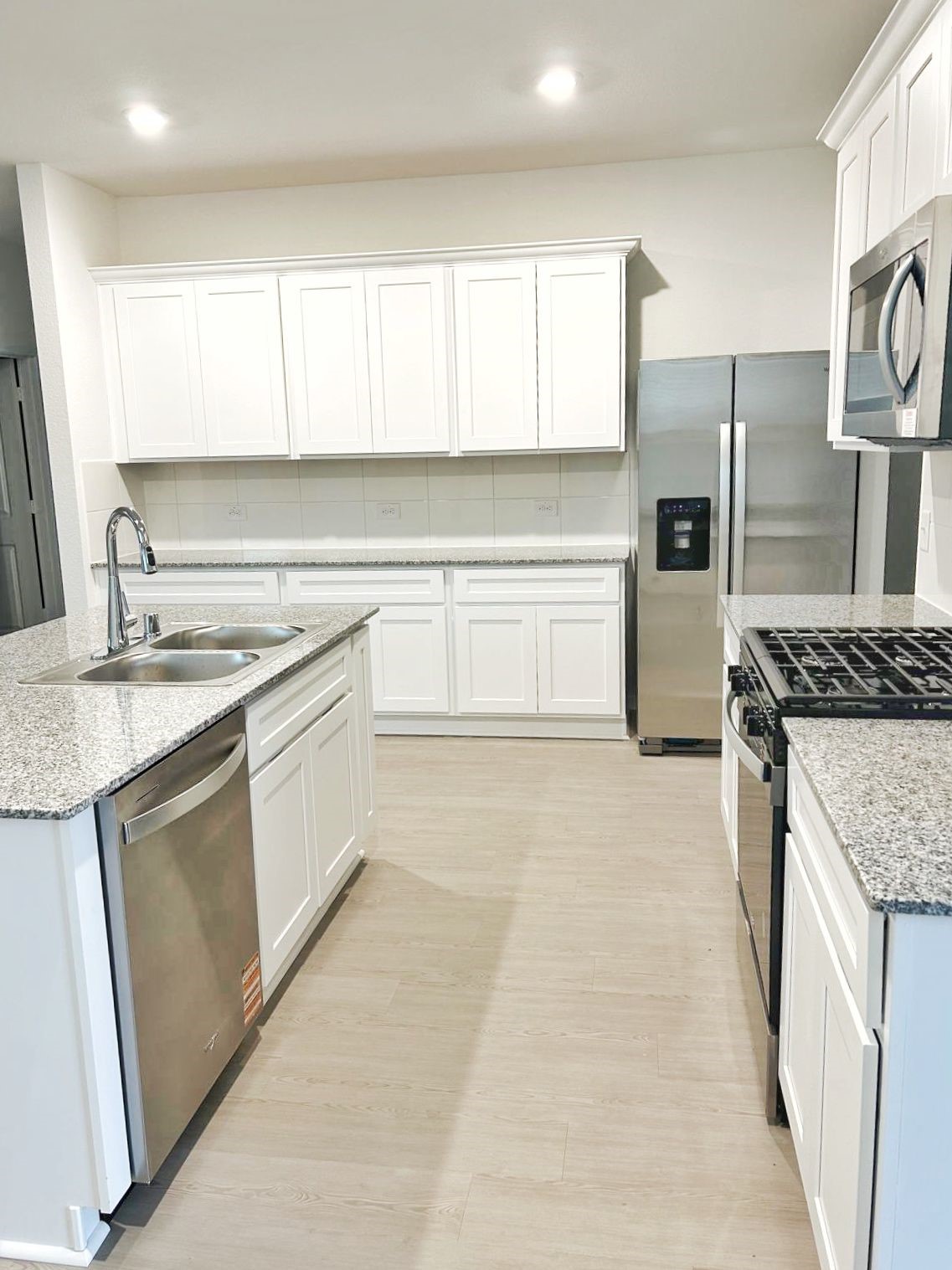 14973 Rustic Moon Road Conroe, TX 77302 - Photo 5 of 22 a kitchen with a sink stove and refrigerator